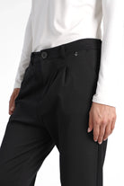 Schwarze HEELENA OG Tapered Pants Cropped mit leichtem Bundfalten und schlank zulaufendem Bein, getragen mit weißem Oberteil.