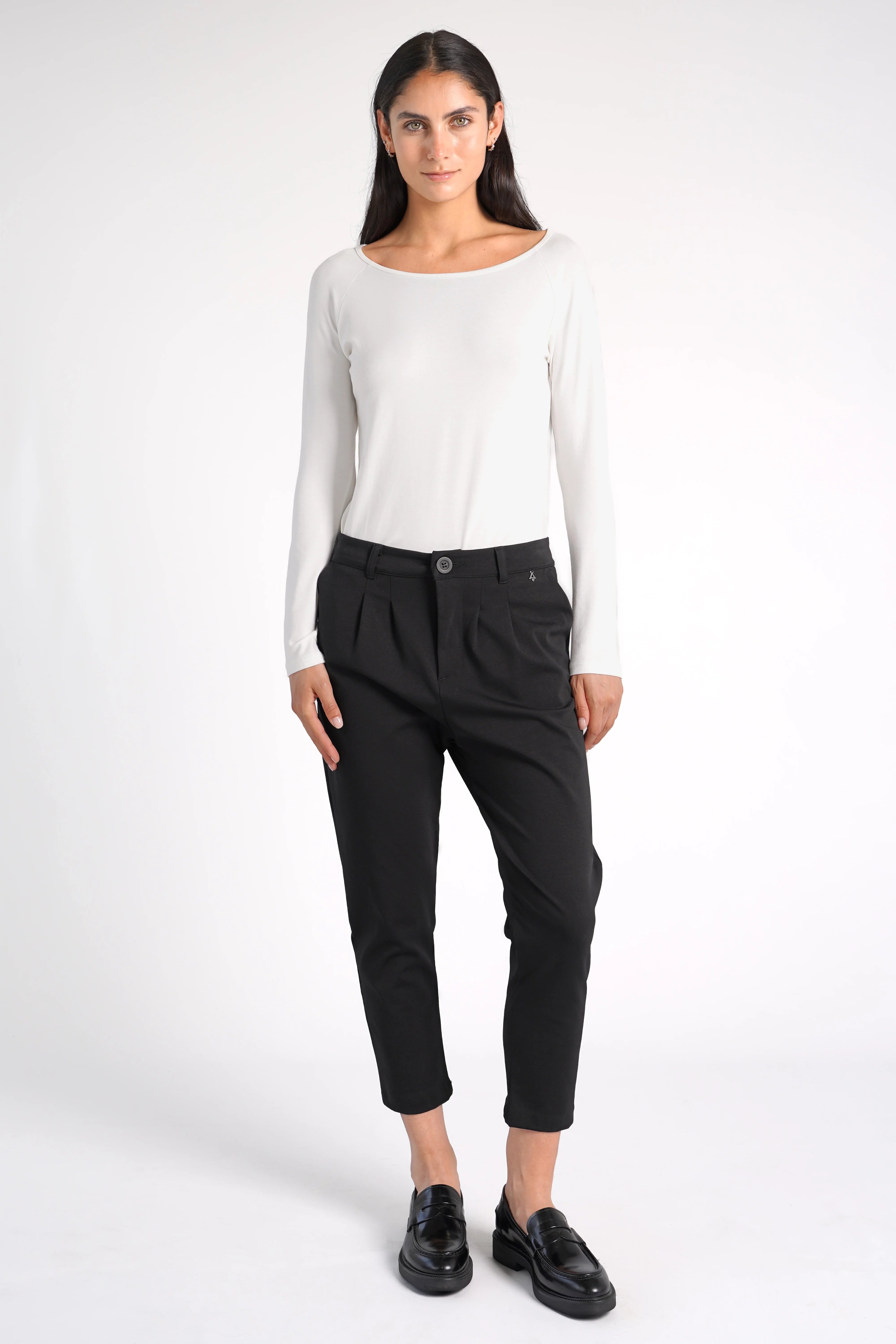 Frau trägt schwarze HEELENA OG Tapered Pants cropped mit leicht zulaufendem Bein und normaler Bundhöhe.