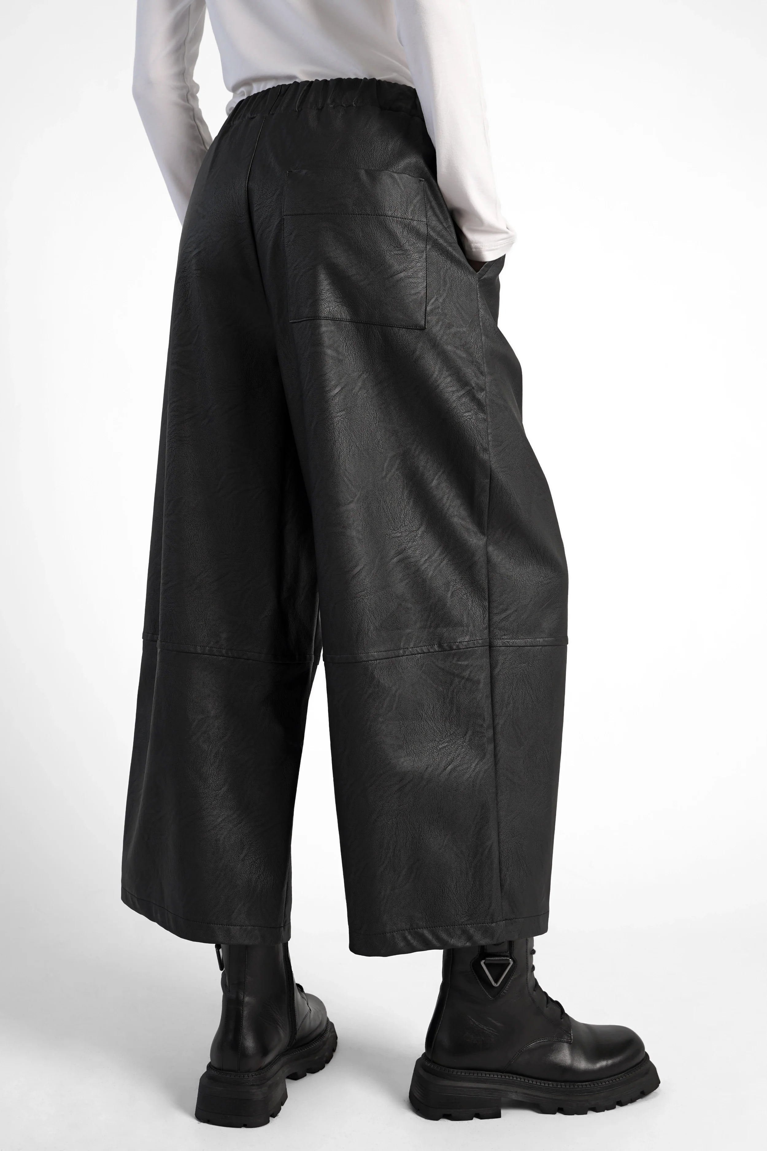Black HERA Wide Leg Hose in soft eco-leather with elastic waistband and side pockets, styled with black boots.