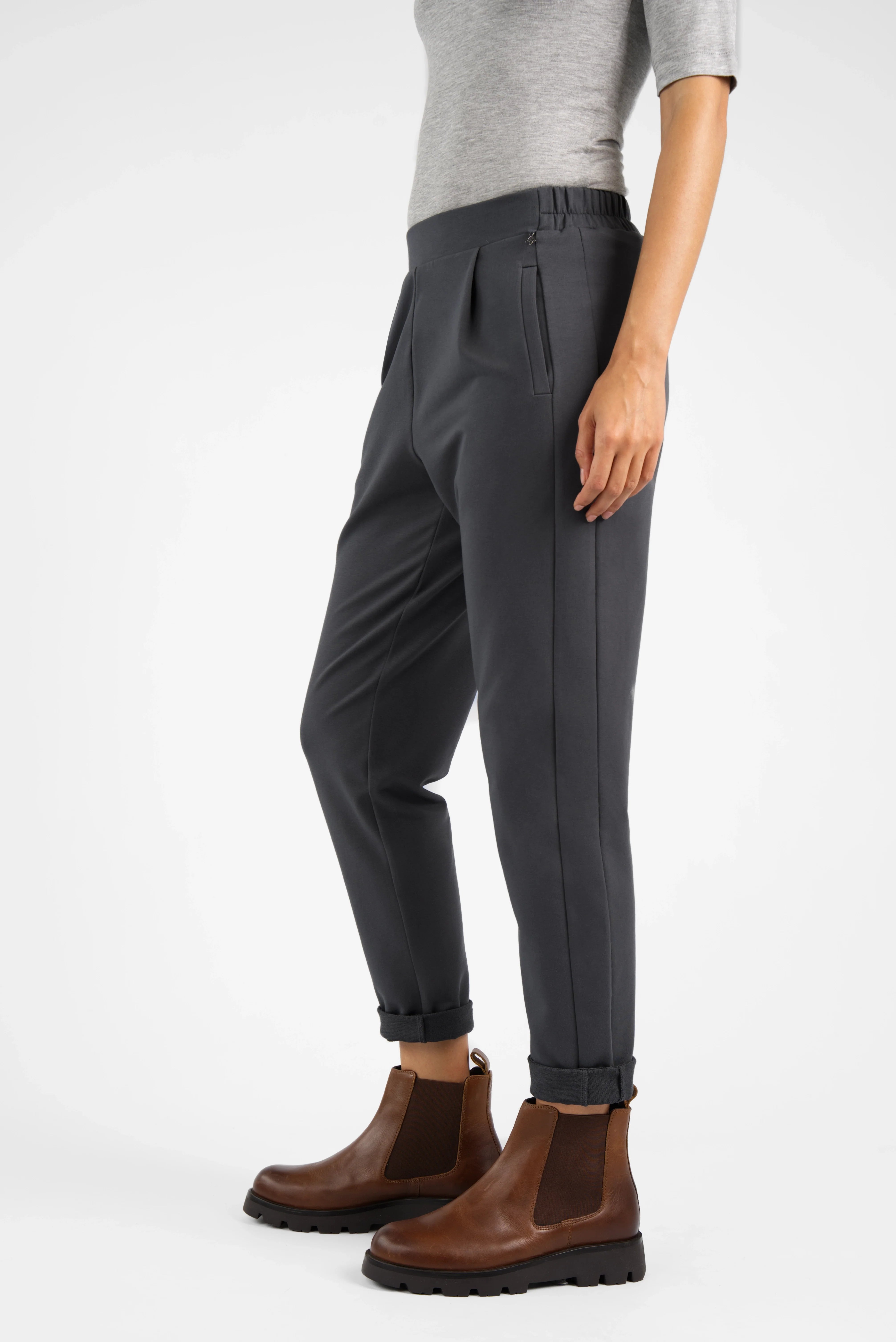 HILLA.K Jerseyhose in schwarzem Baumwollstretch mit mittelhohem Bund und leicht schmal zulaufendem Bein kombiniert mit braunen Chelsea-Stiefeln.