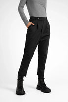 Black JALDI cropped tapered pants with elastic waistband and button detail, worn with black boots.