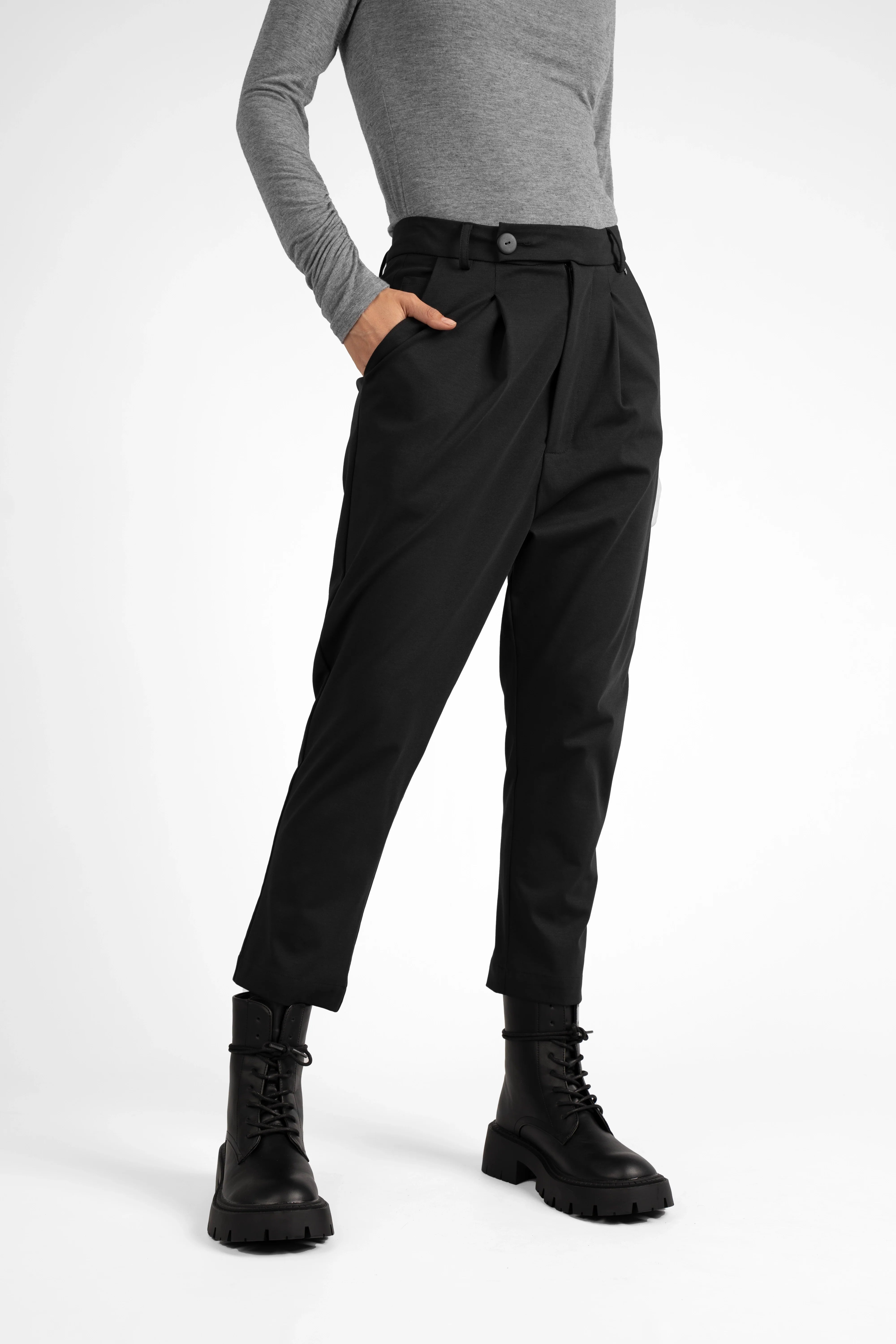 Black JALDI cropped tapered pants with elastic waistband and button detail, worn with black boots.