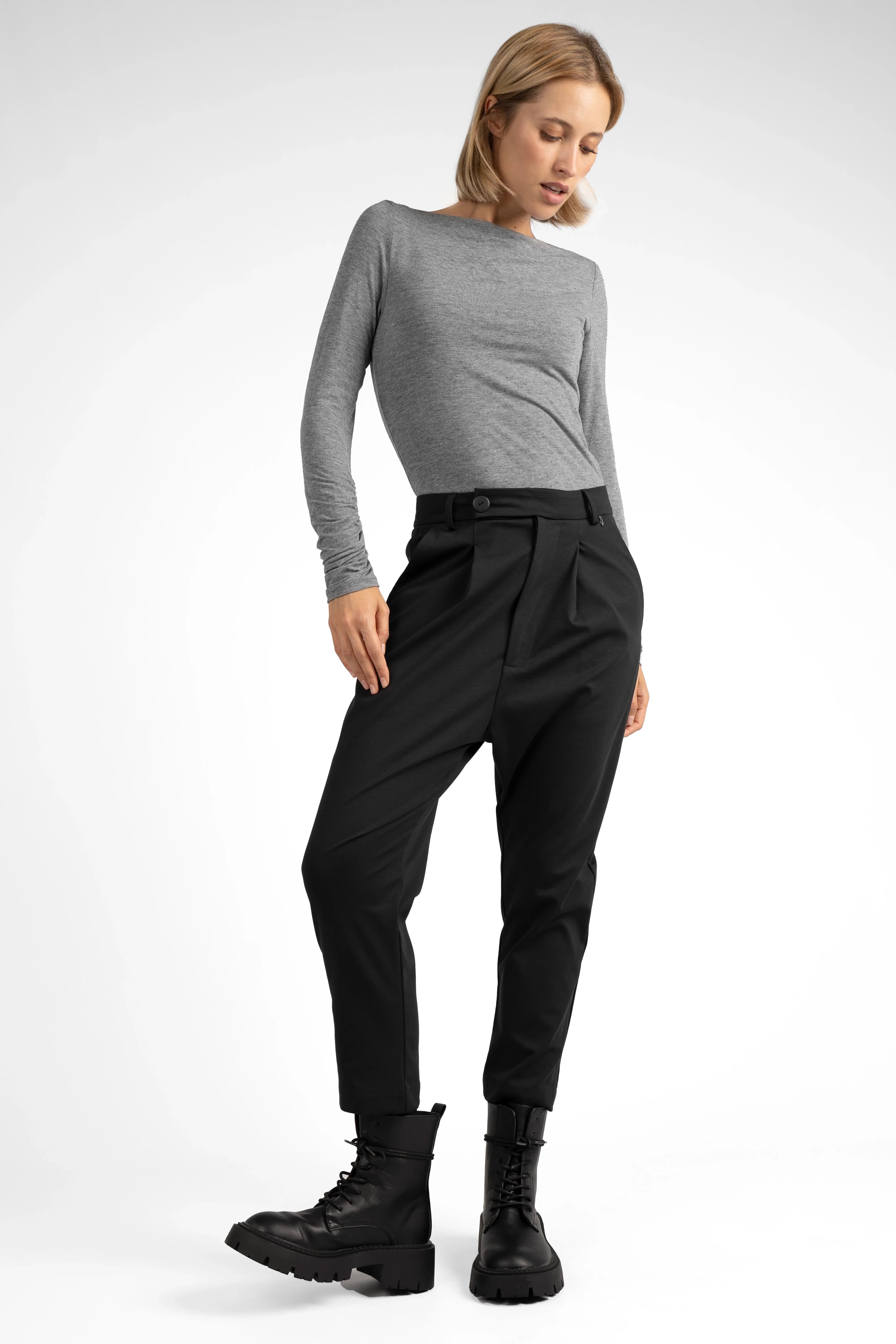Woman wearing JALDI Cropped Tapered Hose black pants with tapered legs and elastic back waistband.