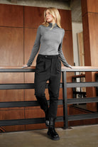 Frau trägt schwarze JALDI Cropped Tapered Hose mit elastischem Bund und schmal zulaufendem Bein in modernem Style