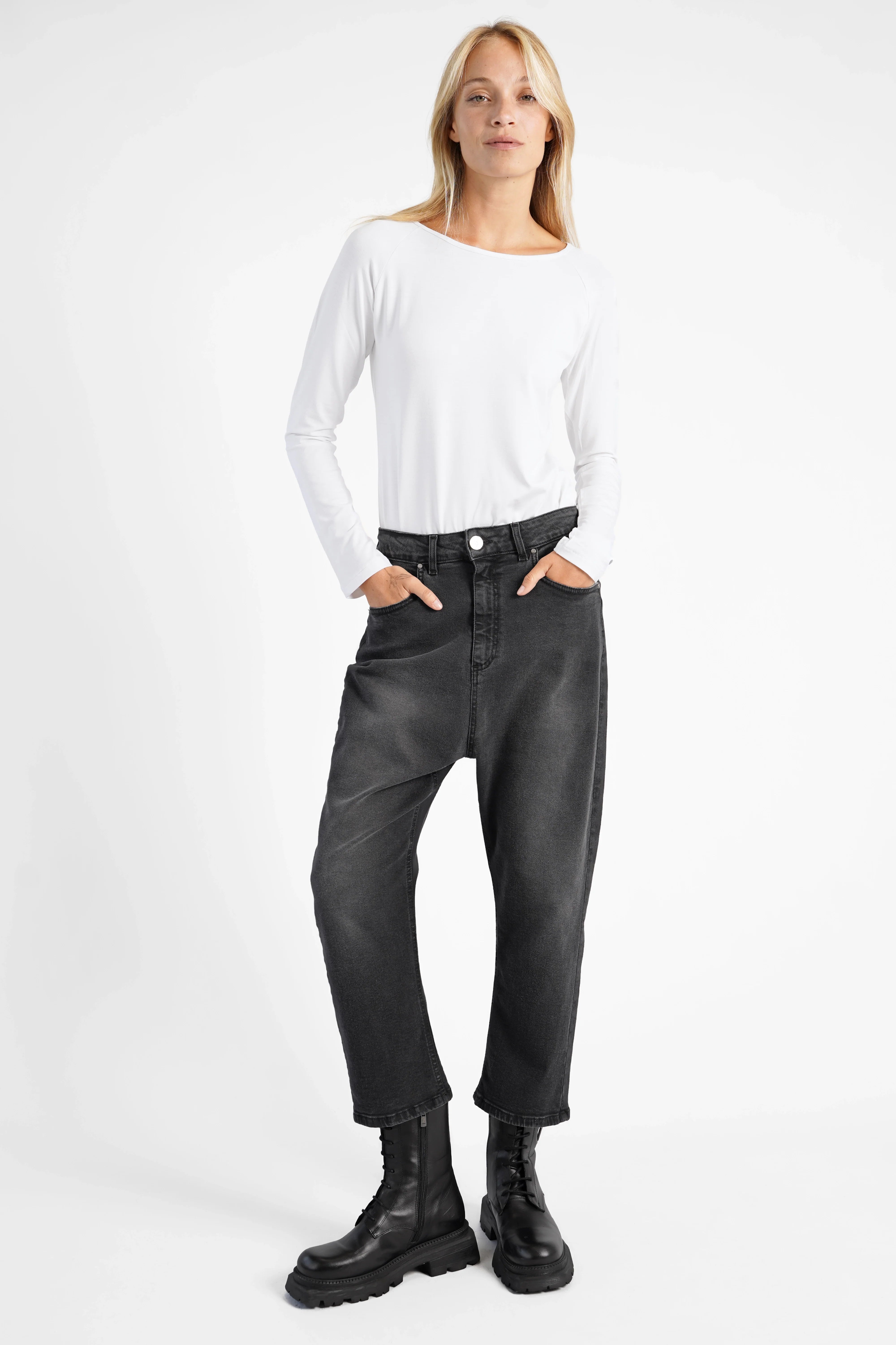 Damen trägt schwarze JEANY Baggy Jeans mit destroyed Waschung, lockerem Sitz und tiefem Schritt.