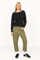 Woman wearing olive green baggy jeans with relaxed fit and black long sleeve top