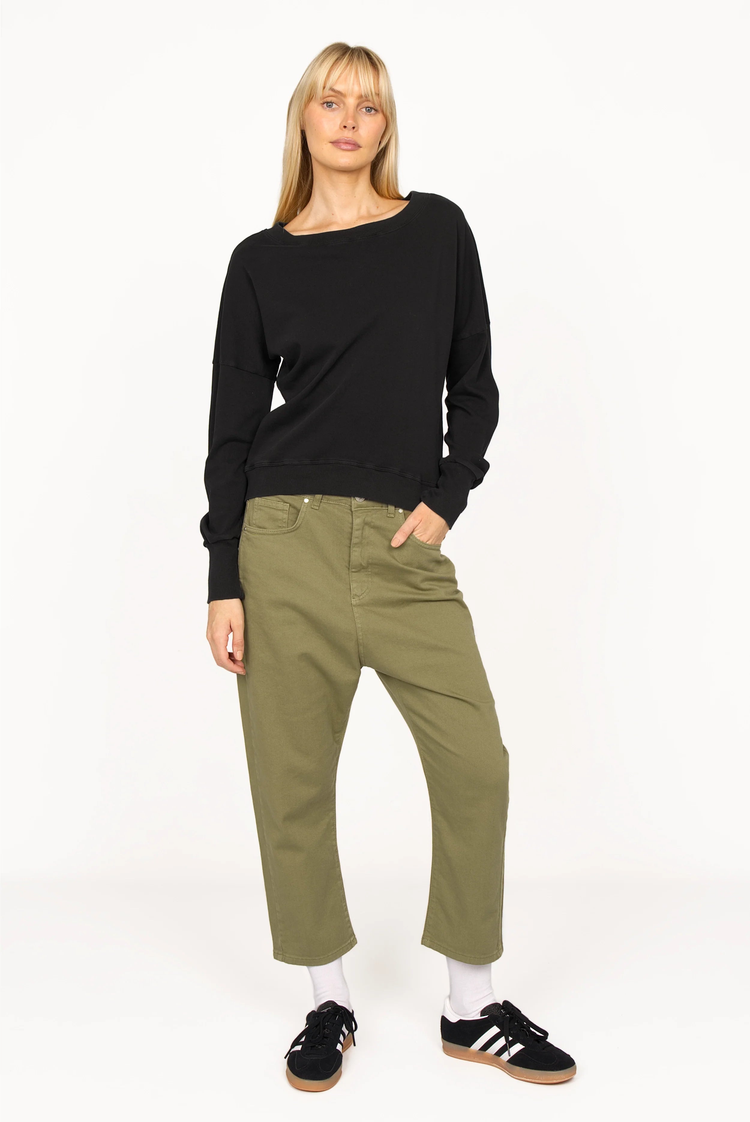 Woman wearing olive green baggy jeans with relaxed fit and black long sleeve top