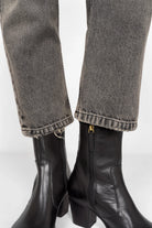 Close-up of grey washed JEANY Baggy Jeans hems paired with black ankle boots