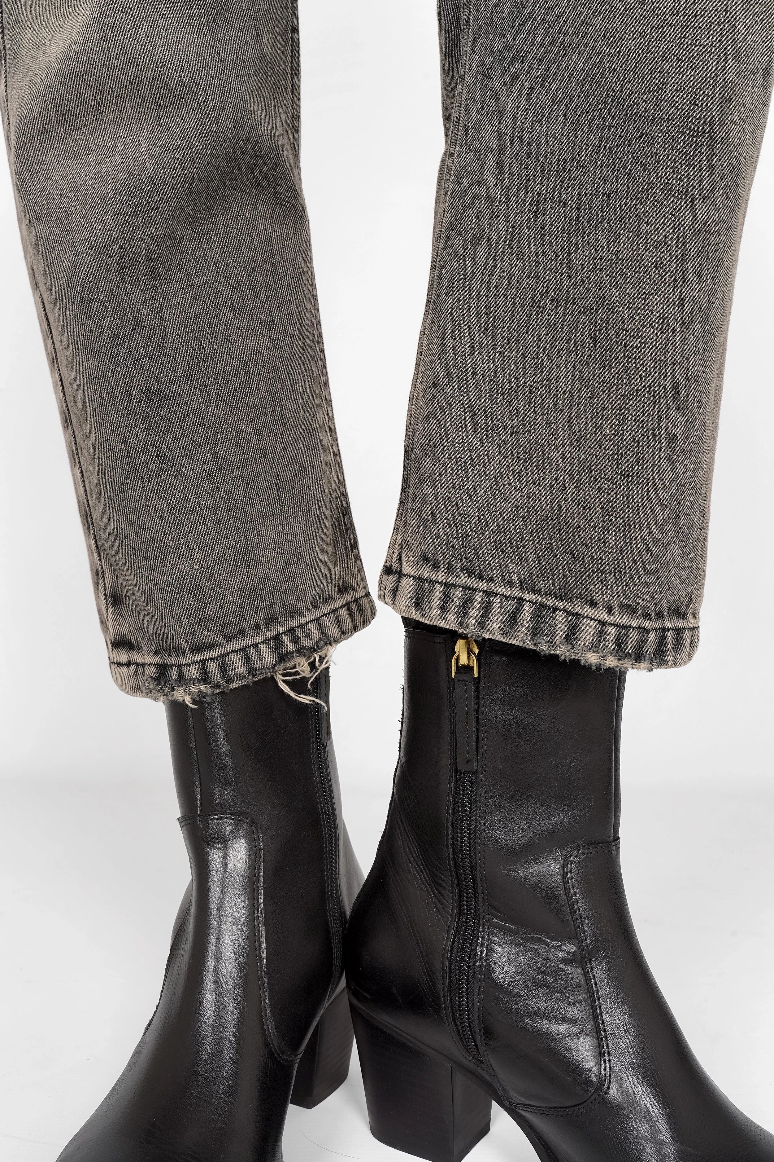 Close-up of grey washed JEANY Baggy Jeans hems paired with black ankle boots