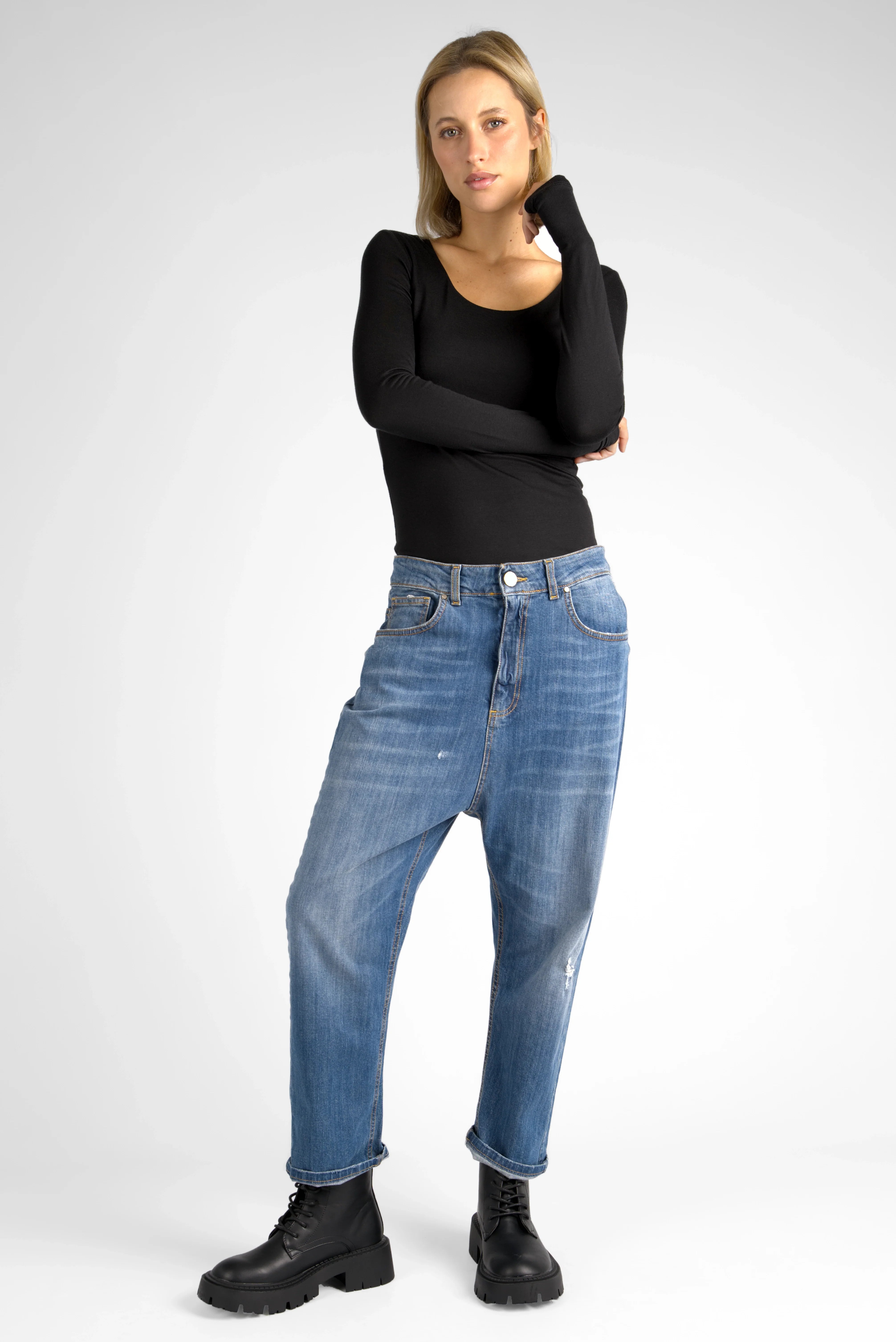 Modell trägt ultralässige Jeany Baggy Jeans mit destroyed Waschung und relaxed Fit, kombiniert mit schwarzem Oberteil und Boots.