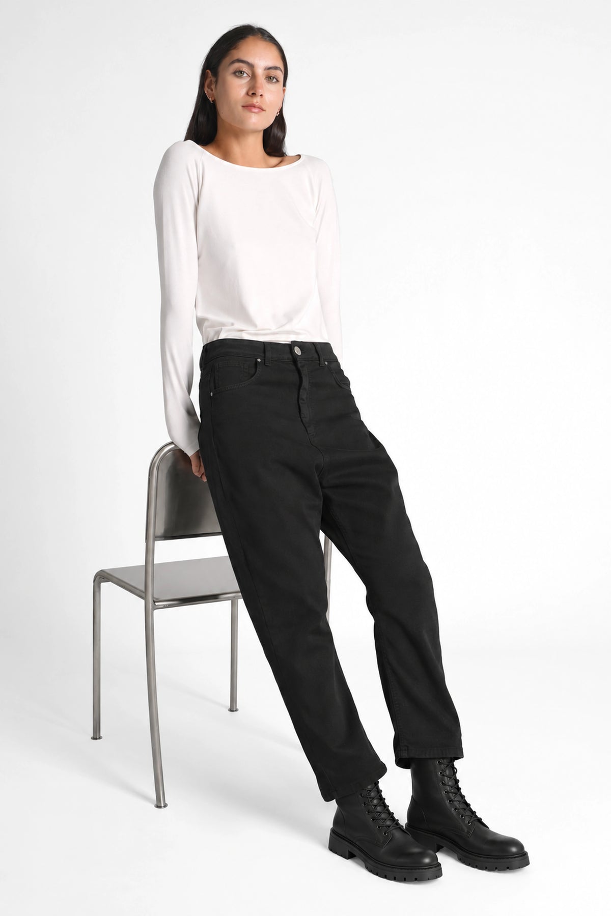 Schwarze JEANY Baggy Jeans mit tiefem Schritt und schwarzen Schnürboots, Ganzkörperansicht am Stuhl