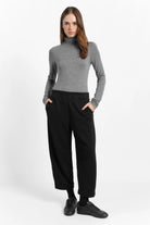 Woman wearing black JOUDY Carrot Jogpant with elastic waistband and side pockets, styled with gray turtleneck and black sneakers.