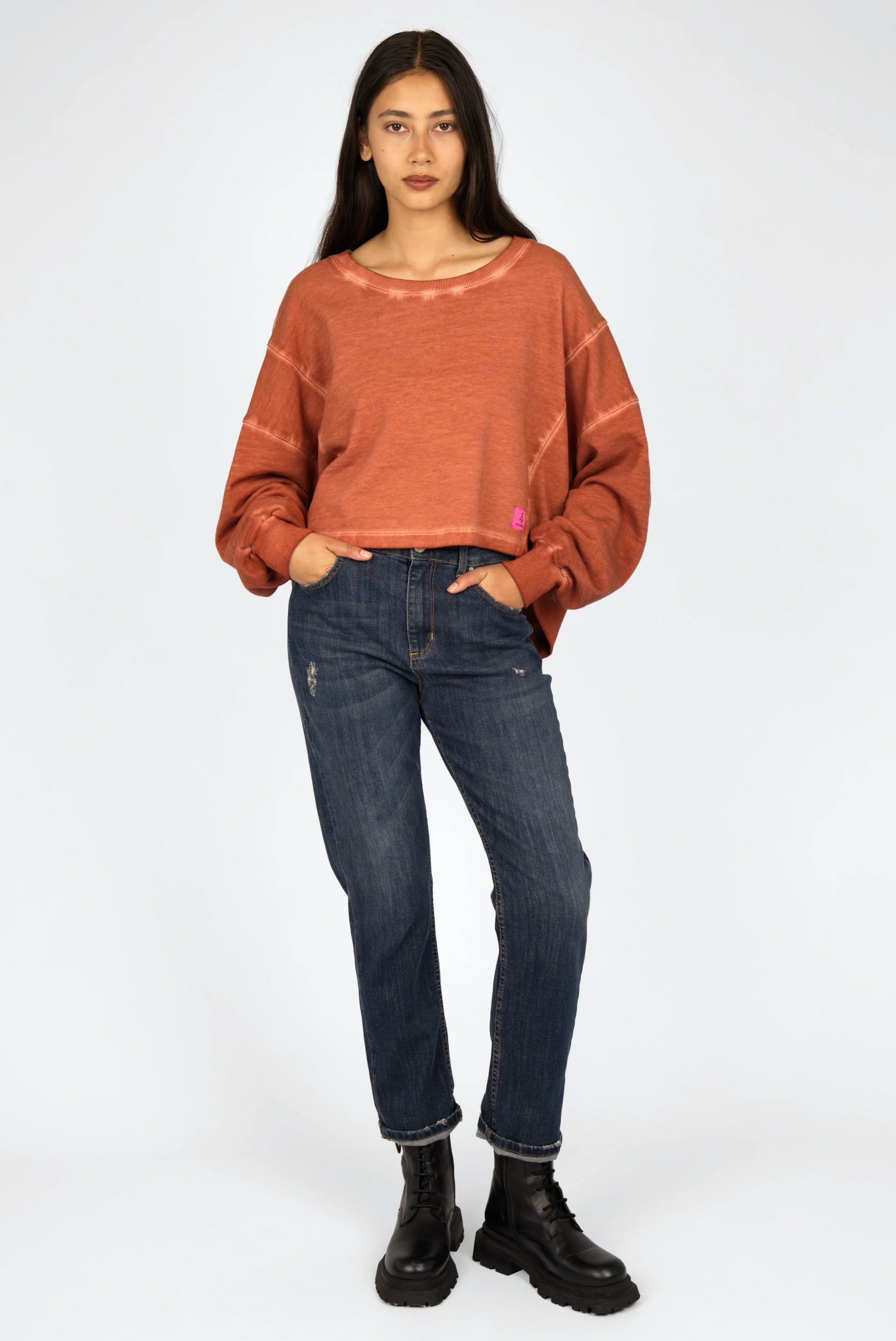 Frau trägt KERY Cropped Sweater in oversized Passform mit U-Boot-Ausschnitt und cold-washed Baumwolle in rostrot
