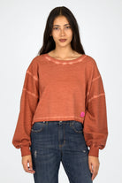 KERY Cropped Sweater aus cold-washed Baumwolle mit U-Boot-Ausschnitt, oversized Passform und pinkem STUDIO Logo-Patch
