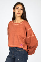 Frau trägt KERY Cropped Sweater in oversized Passform mit U-Boot-Ausschnitt und cold-washed Baumwoll-Sweat in Rostrot