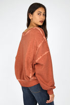 Damen trägt KERY Cropped Sweater in oversized Passform mit U-Boot-Ausschnitt und cold-washed Baumwoll-Sweat in rostfarben