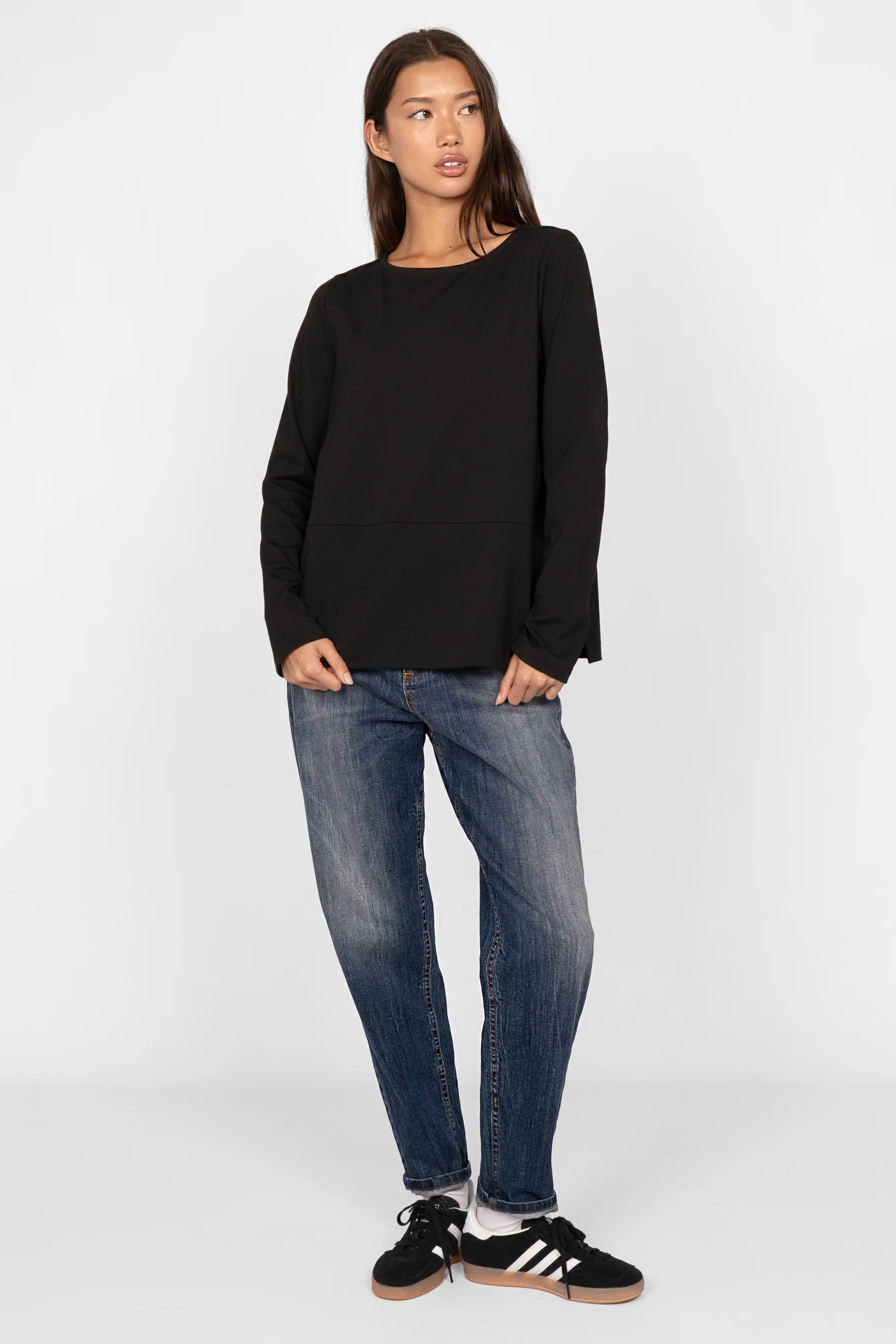 Frau trägt KEYSSI Carrot-Jeans in dunkelblauer Waschung mit sanften Fade-Details und Mid Waist Schnitt