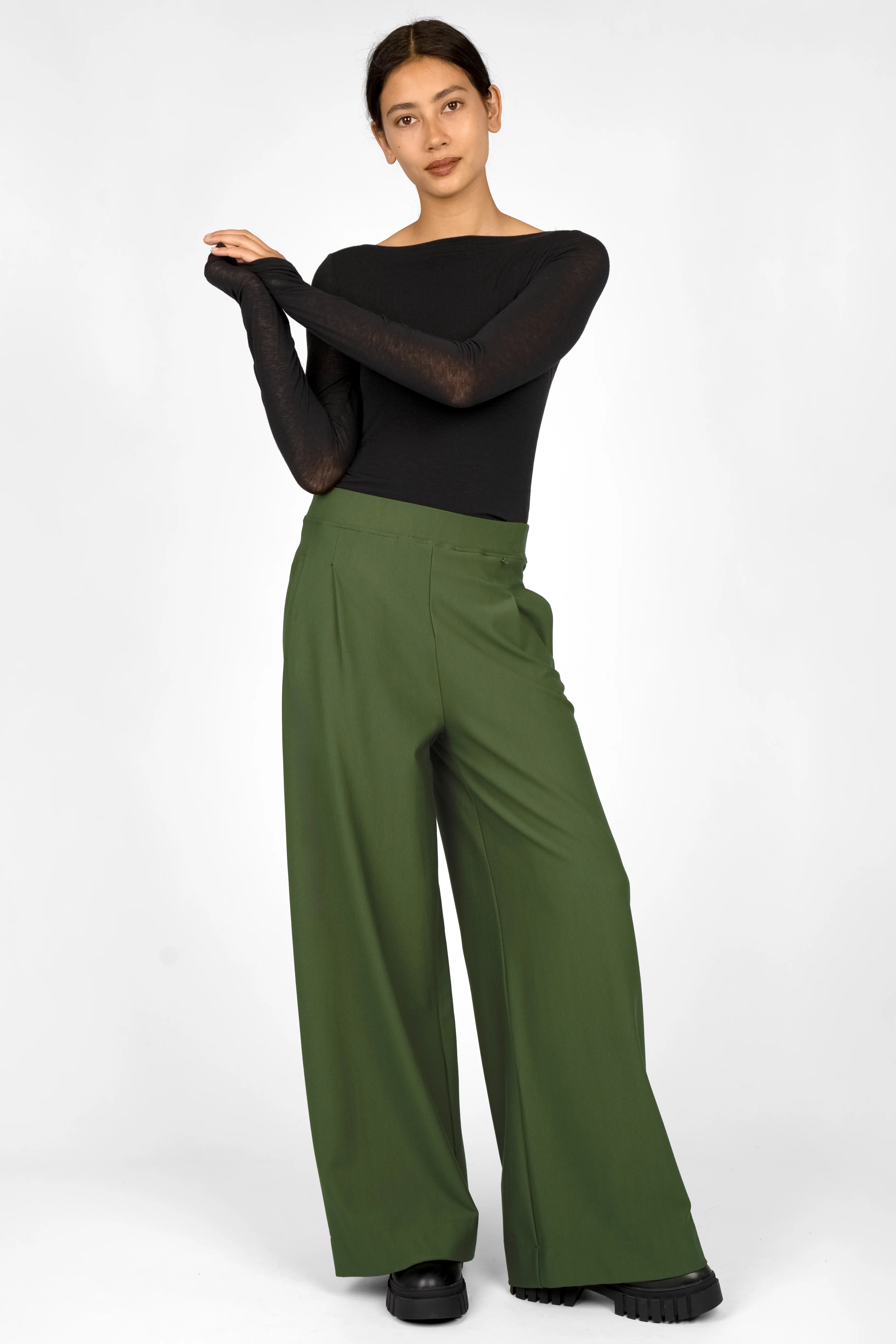 Woman wearing KLARA.K wide-leg green pants with elastic waistband and side pockets paired with a black fitted long sleeve top