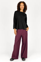 Frau trägt KLARA.K Wide Leg Pants in Bordeaux mit elastischem Bund und seitlichen Taschen