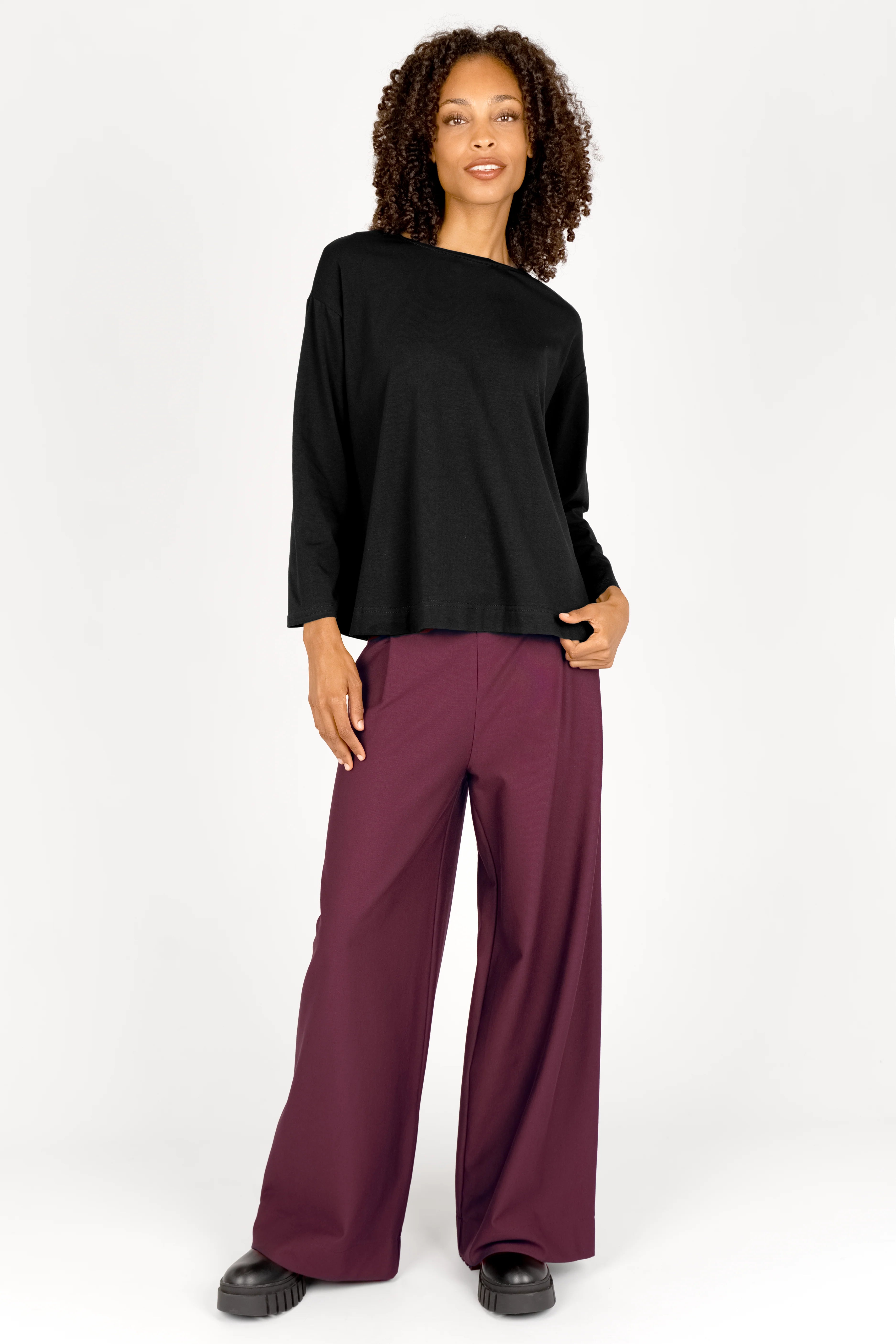 Frau trägt KLARA.K Wide Leg Pants in Bordeaux mit elastischem Bund und seitlichen Taschen