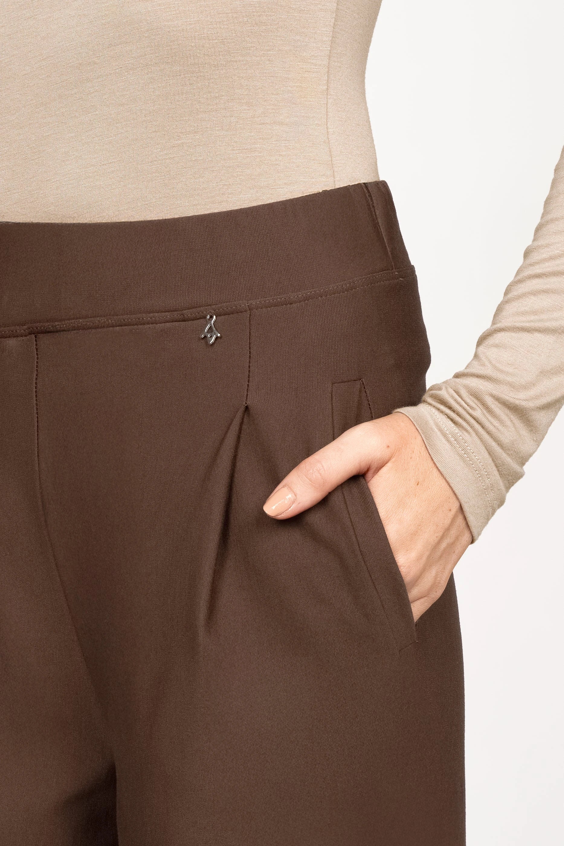 Close-up of brown KLARA.K Wide Leg Pants with elastic waistband, subtle pleats, and side pockets worn with beige top