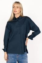 Woman wearing navy blue LEA.K loose fit blouse with long sleeves and button-up front
