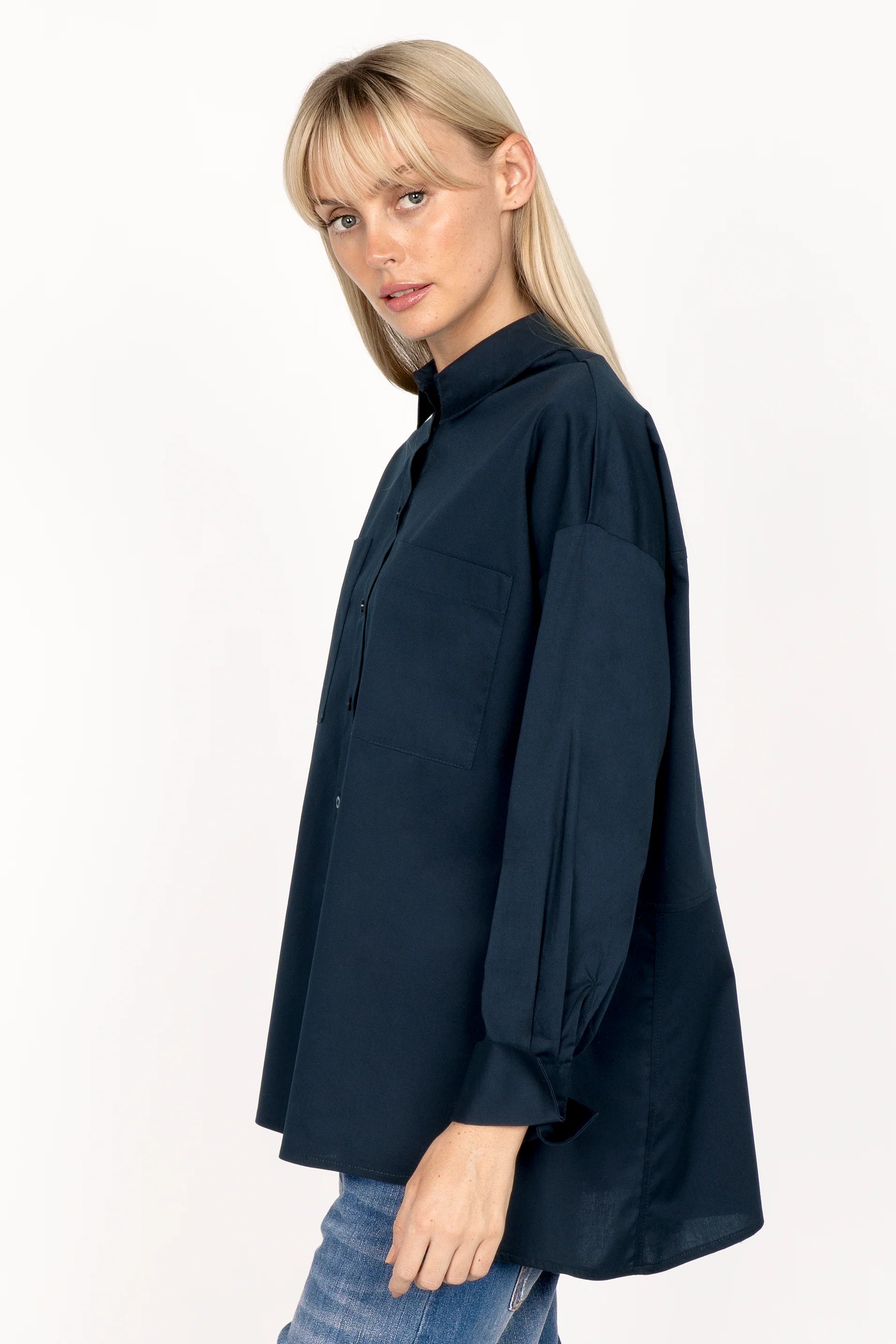 Woman wearing navy LEA.K Loose Fit Bluse with hem collar, chest pockets, and extended back length