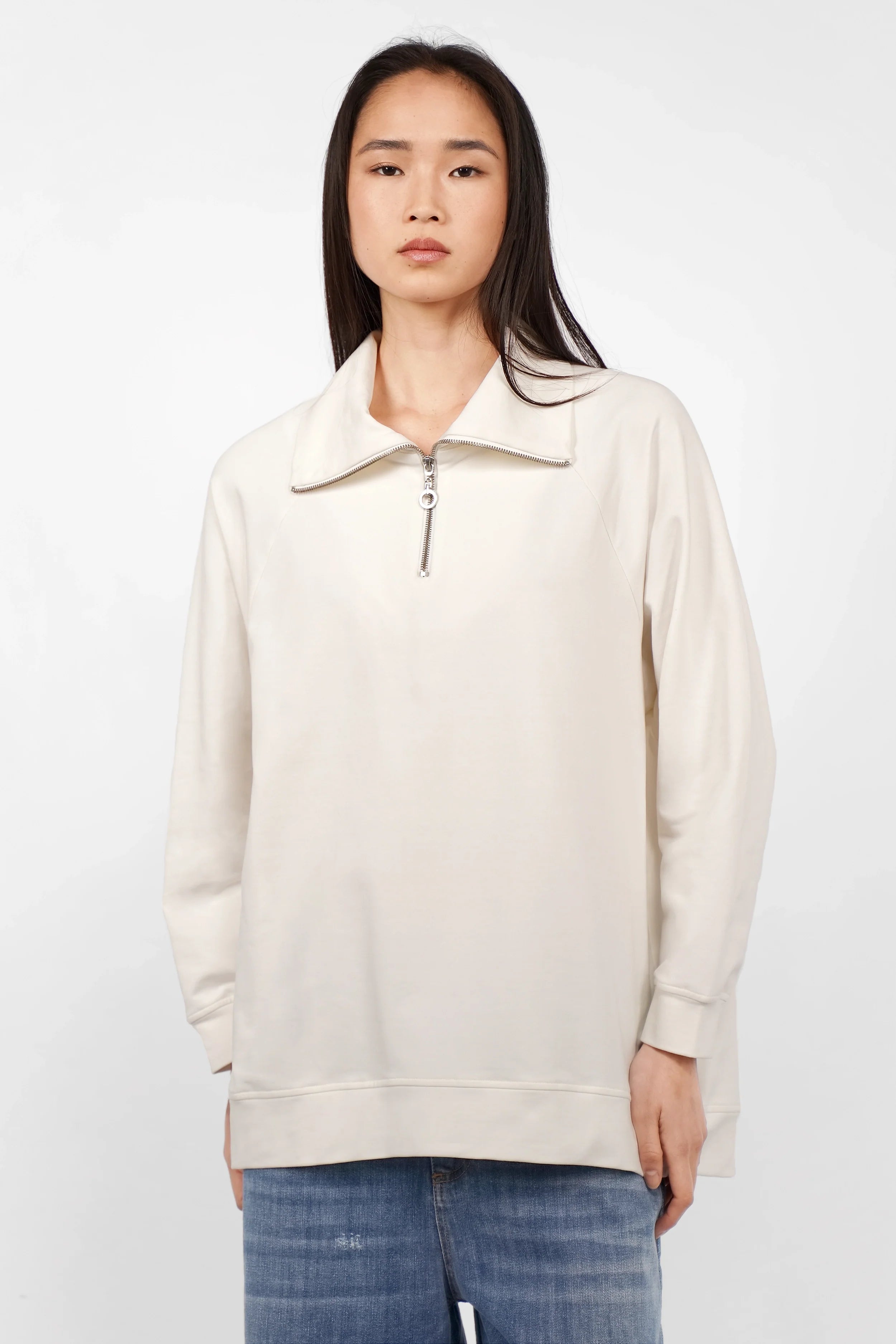 Damen Troyer-Oversize Sweater in Cremeweiß mit Halb-Zip und Stehkragen, oversized Passform, Raglanärmeln und abgerundetem Saum.