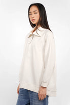 Lenia Troyer-Oversize Sweater in cremeweiß mit halbem Reißverschluss und Raglanärmeln