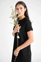 LISSY Kurzarm Sweatkleid in Schwarz mit Rundhalsausschnitt, Raglanärmel und Seitentaschen.