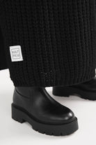 LOLA Strickcardigan in schwarz mit lockerem Oversize-Schnitt und sichtbarem Kultfrau-Label am Saum
