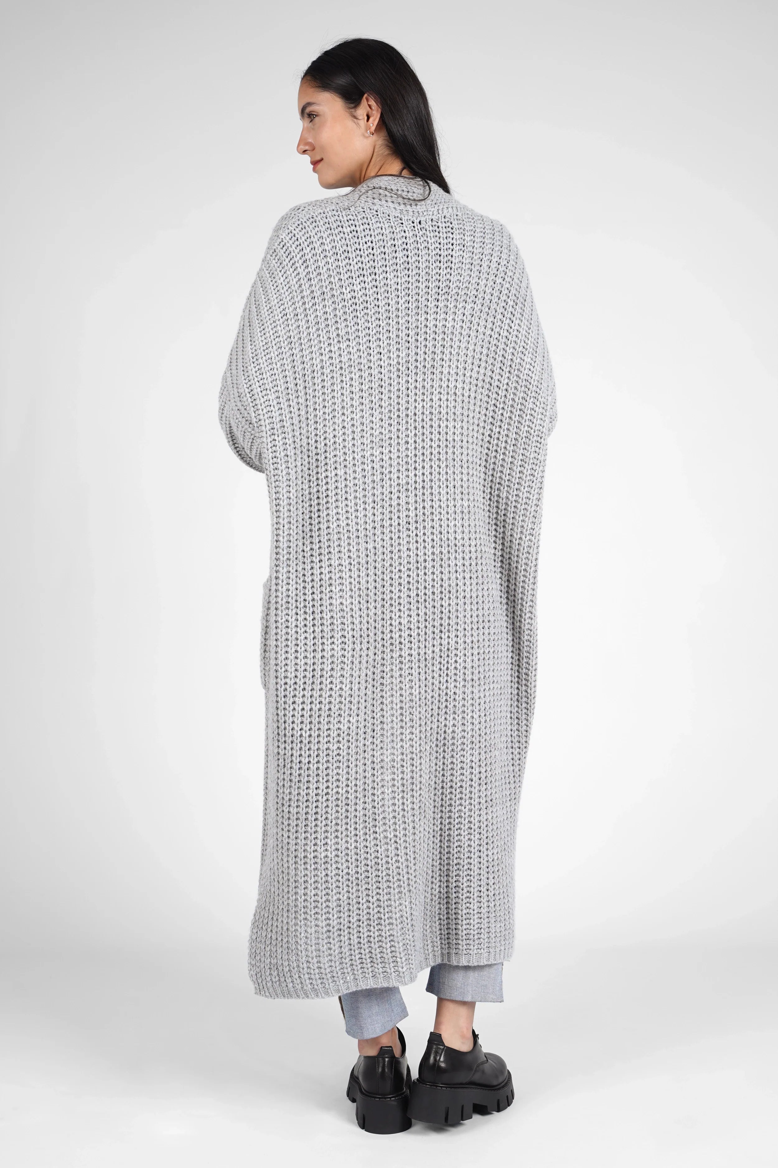 Woman wearing a long, gray oversized LOLA Strickcardigan with a relaxed fit and open front, viewed from the back.