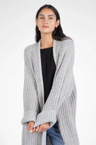 Woman wearing light gray LOLA Strickcardigan open knit oversized cardigan with relaxed fit and rolled sleeves