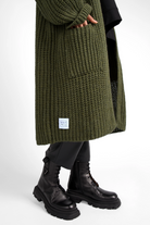 Oversized olive green LOLLYTA Strickcardigan with front pockets and relaxed fit worn with black leather boots