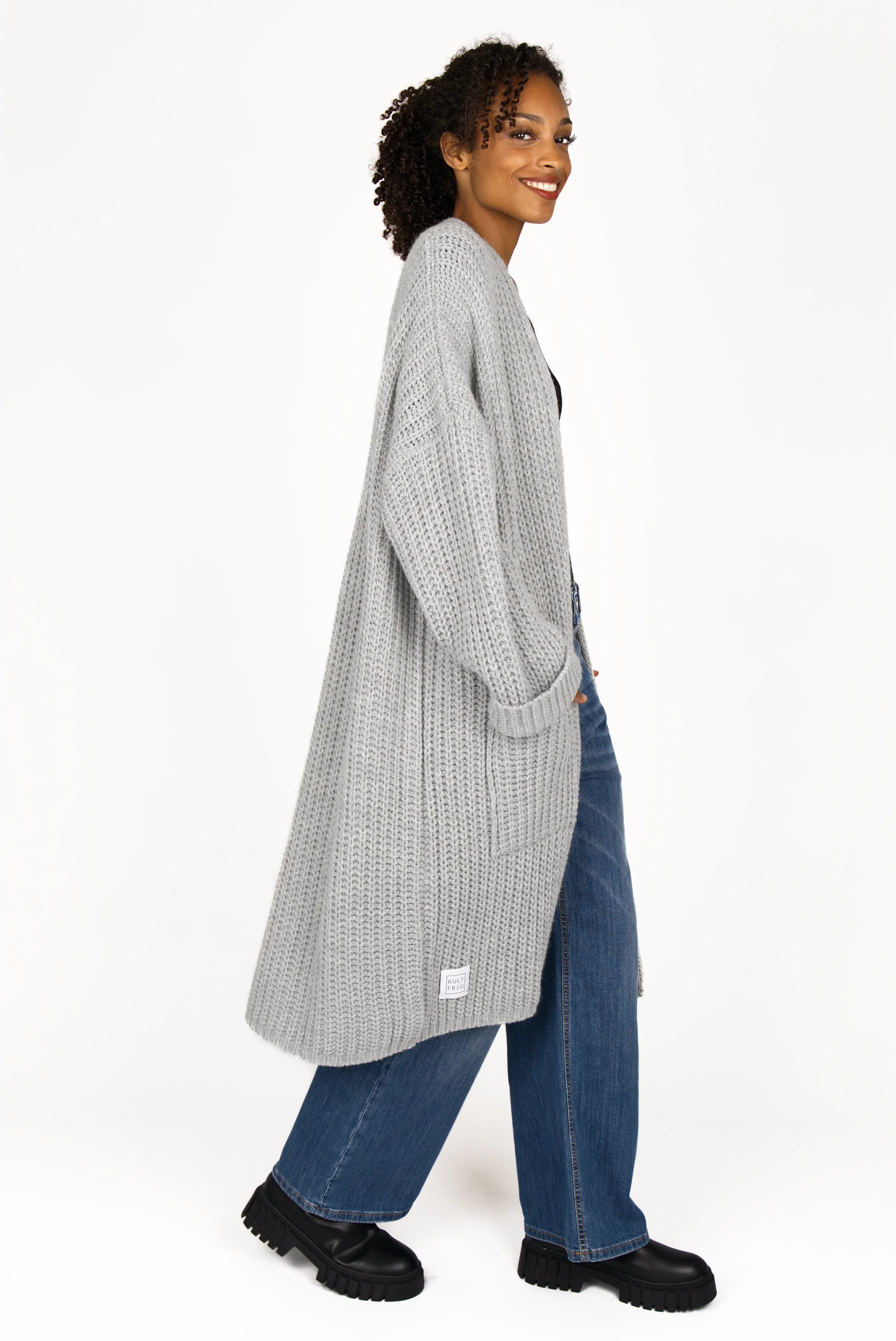 Woman wearing grey oversized LOLLYTA Strickcardigan with relaxed fit, open front, and patch pockets.