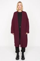Frau trägt LOLLYTA Strickcardigan oversized in bordeaux offen mit aufgesetzten Taschen