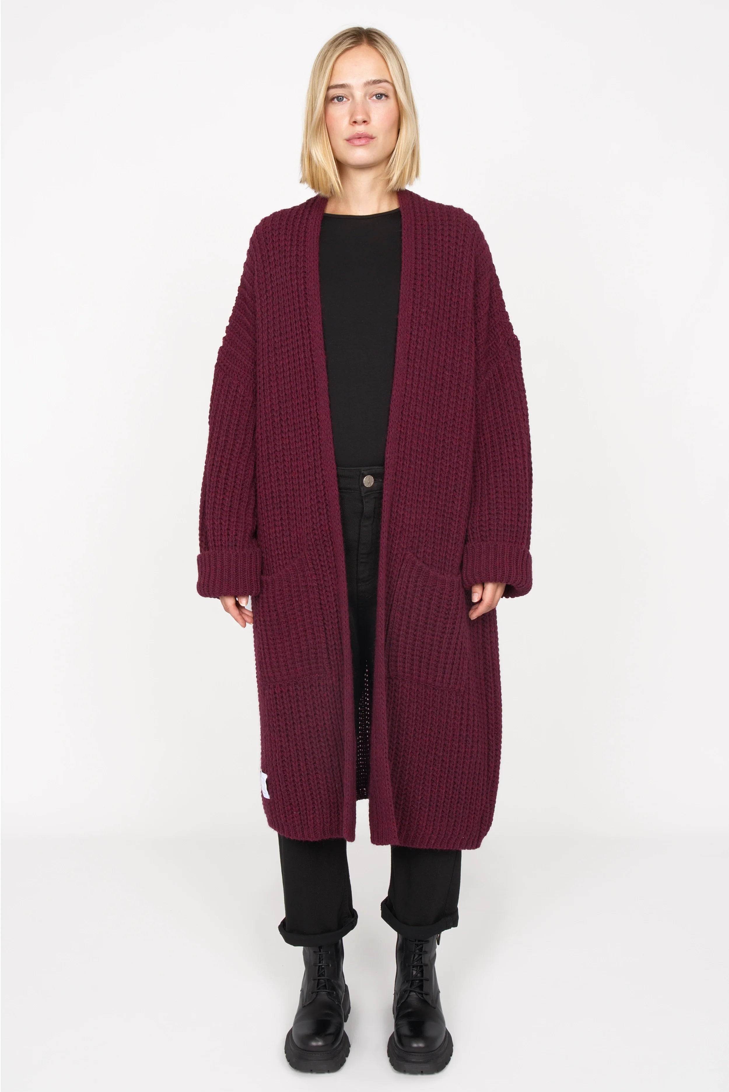 Frau trägt LOLLYTA Strickcardigan oversized in bordeaux offen mit aufgesetzten Taschen