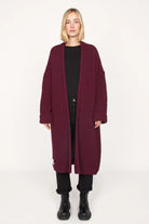 Woman wearing oversized LOLLYTA Strickcardigan in deep burgundy with relaxed fit and front pockets.