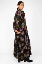 Woman wearing LUSIIA Maxikleid floral print maxi dress with long sleeves and high collar