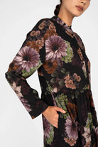 LUSIIA Maxikleid with floral all-over print, long sleeves, button placket, standing collar, and side pockets on black flowing fabric