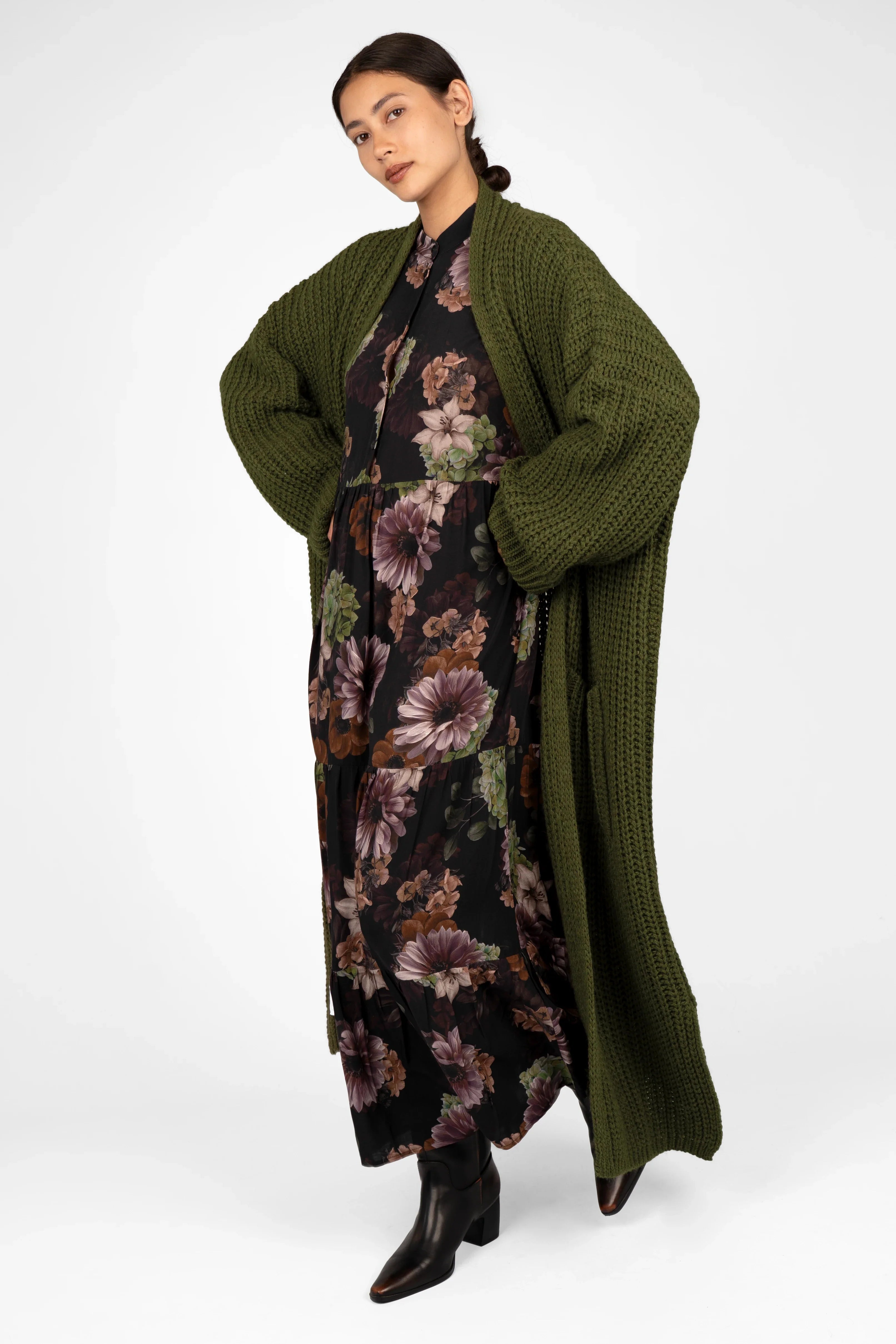 Damen trägt LUSIIA Maxikleid mit floralem All-Over-Print und grüner Strickjacke