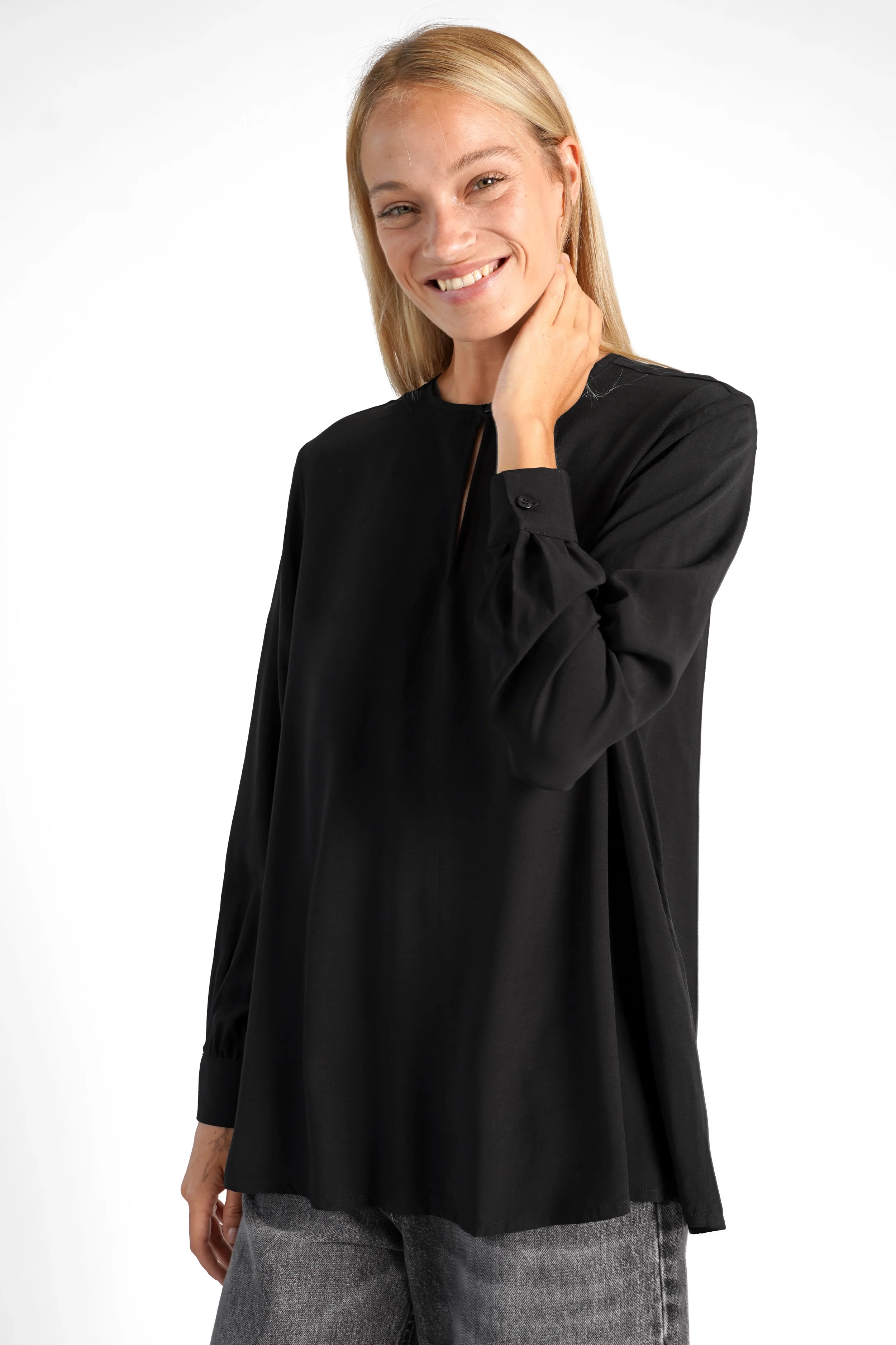 Woman wearing black LYLIA.K loose fit blouse with V-neck and long sleeves