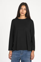 Woman wearing black LYLLDA Viskose Longsleeve with round neckline and relaxed fit.