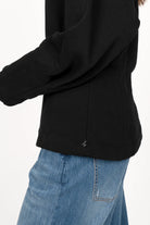 Black MALVEA Sweater with relaxed fit and structured seam details, worn with blue jeans.