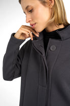 Close-up of a woman wearing a dark grey MANEY Sweatmantel with a concealed button placket and brushed jersey fabric for comfort.