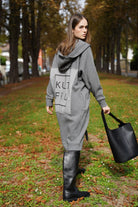 woman wearing oversized grey Longzip-Hoodie with back logo patch walking outdoors in autumn