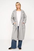 Woman wearing a gray MONDY.K Oversize Sweatmantel with large pockets and a lapel collar.