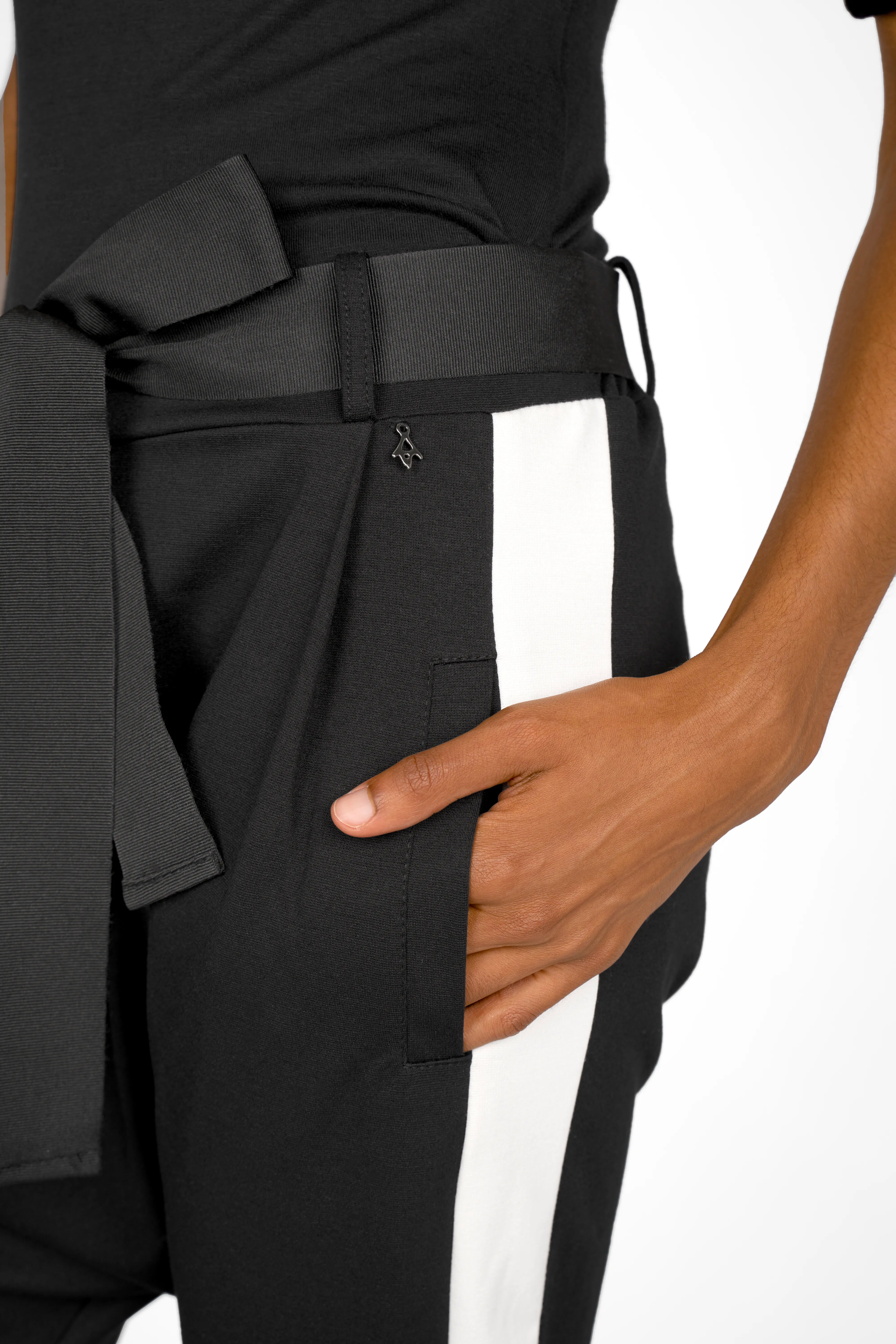 Close-up of black MYRAN Tapered Sweathose with white side stripes, tapered leg, and tied belt detail.