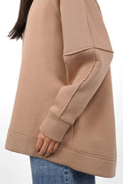 Side view of NAIRA Cozy Sweater in beige with soft brushed cotton and relaxed A-line fit