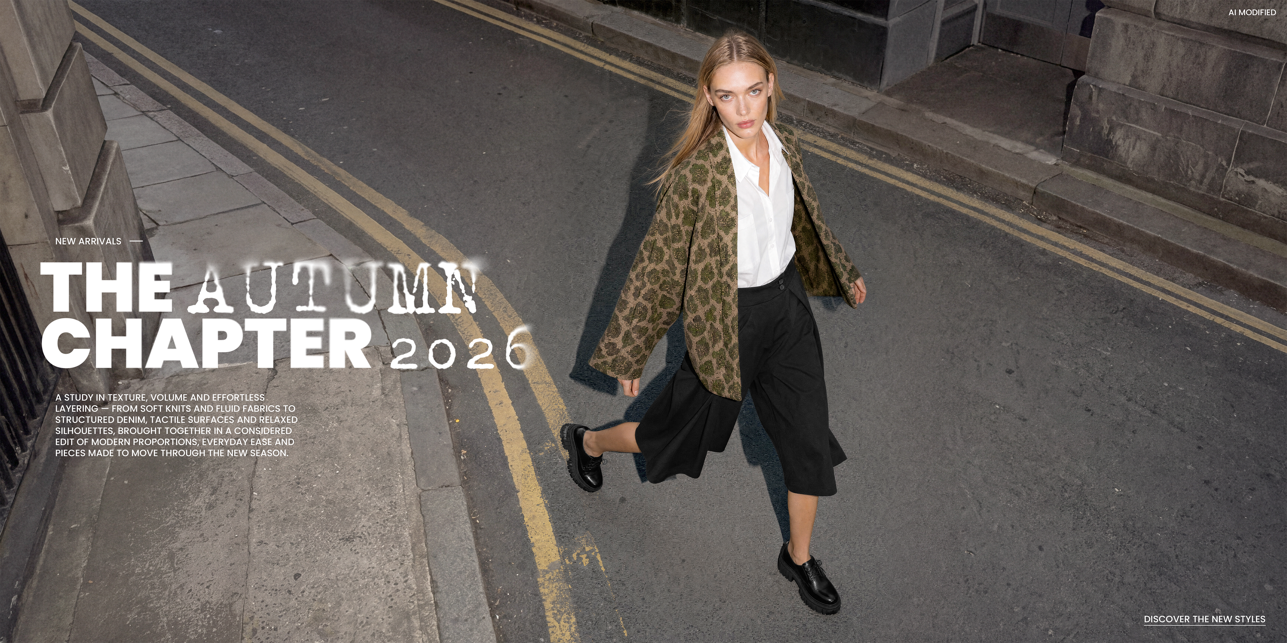 Model in braun-grün gemustertem Blazer, weißer Bluse, schwarzer Culotte und schwarzen Schnürschuhen auf einer urbanen Straße, neben dem Schriftzug „The Autumn Chapter 2026“.
